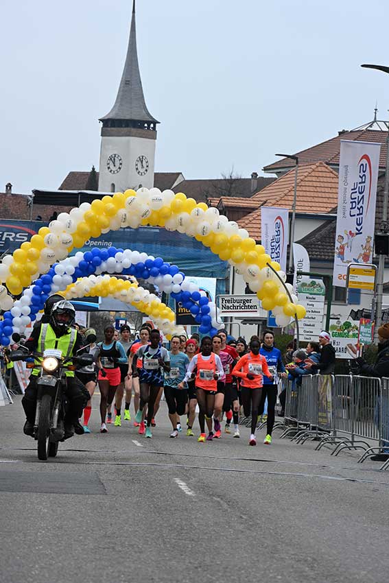 Coureurs sous un arc de ballons.